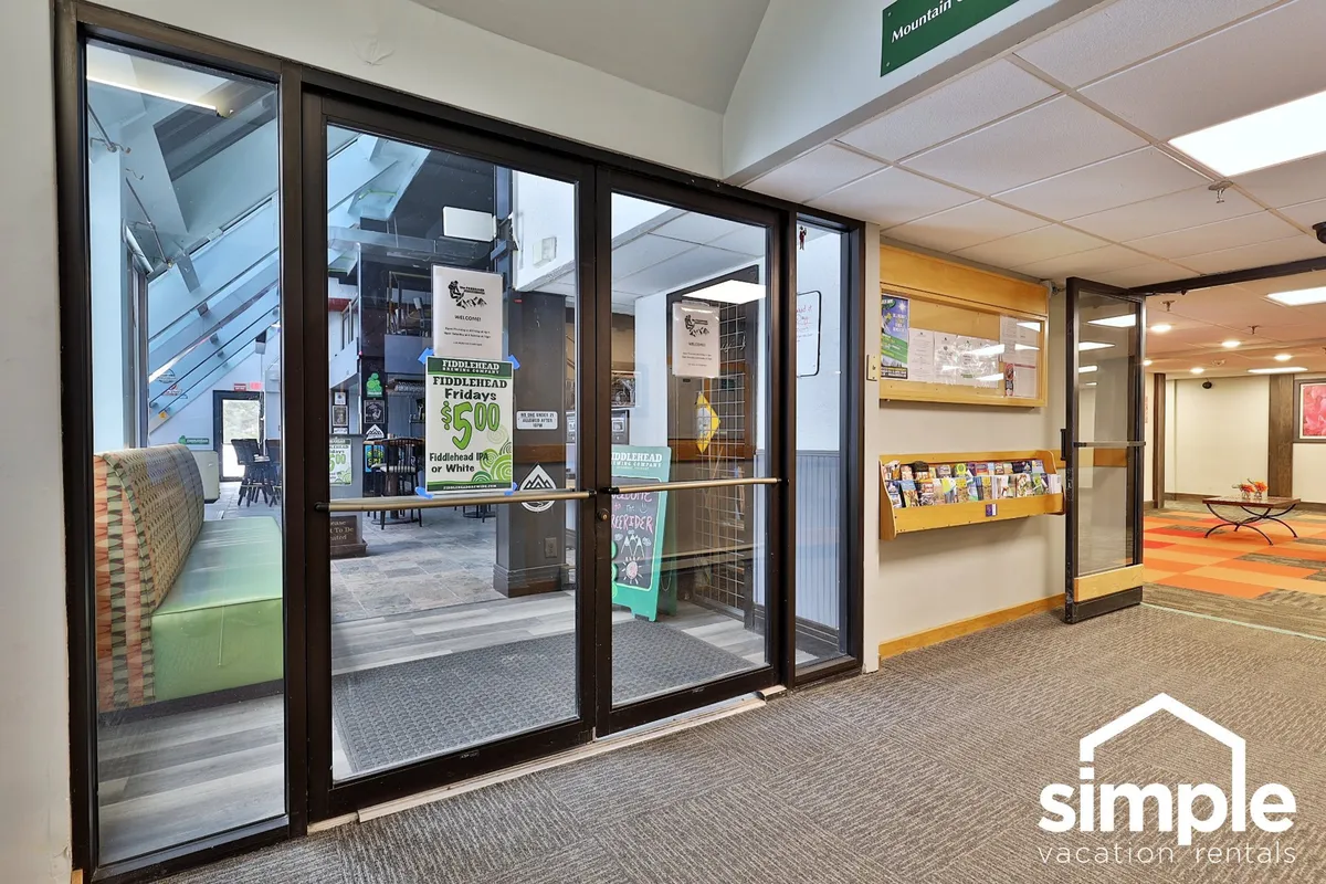 A bright and modern reception area is shown, featuring glass entrance doors, a welcoming reception desk, and a brochure display. The area feels both inviting and functional, reinforcing the resort's organizational strengths.