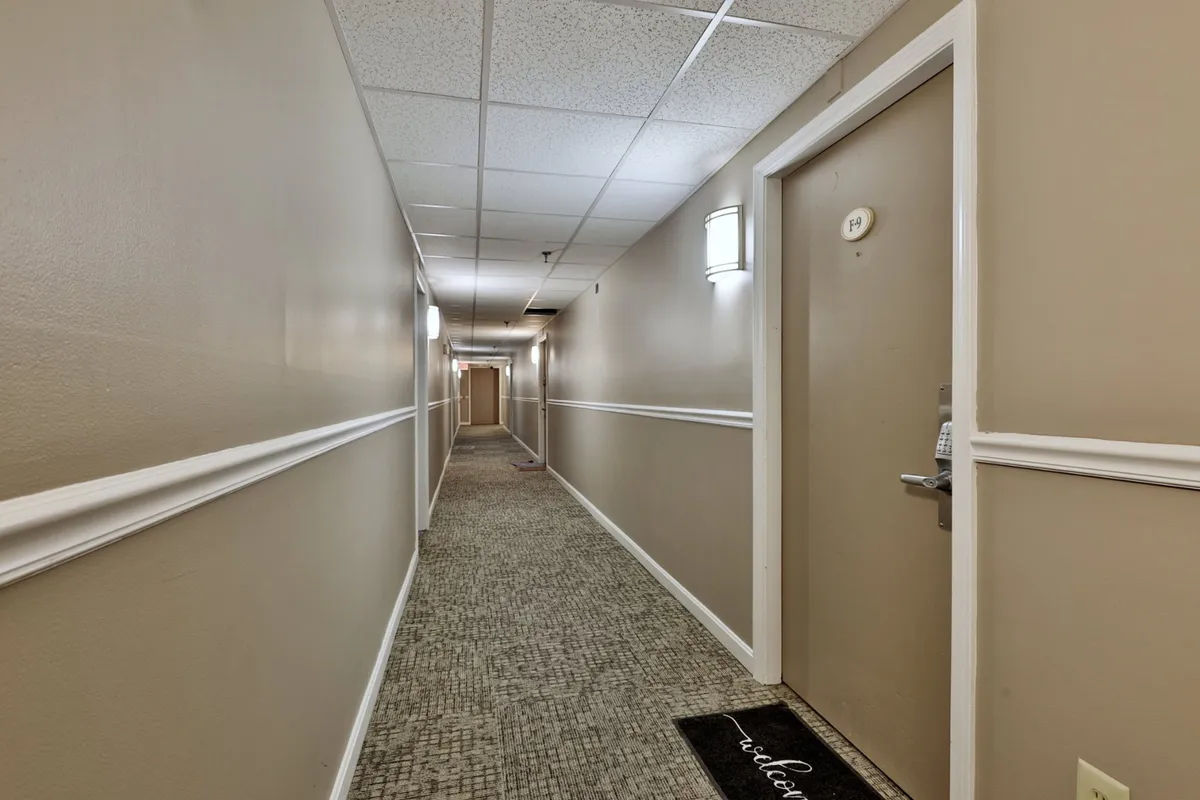 This image showcases a welcoming entryway, complete with a well-lit doorway, contemporary lighting fixtures, and a welcome mat. The scene suggests an inviting and secure arrival experience for guests.